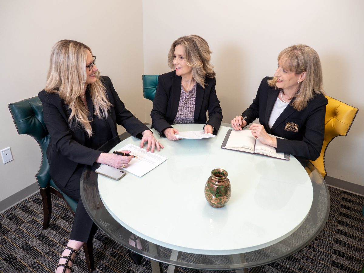 Three women talk at a table
